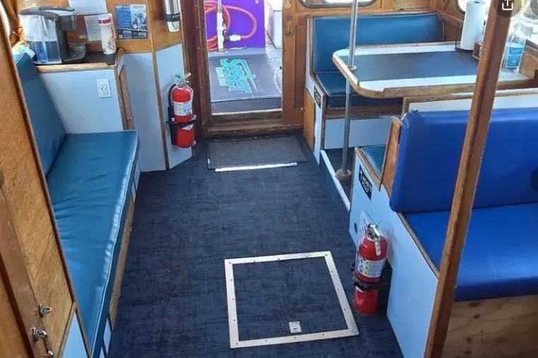 Slide: The Image of Interior of a 1978 Uniflite 50 boat with blue seating and fire extinguishers. - 4