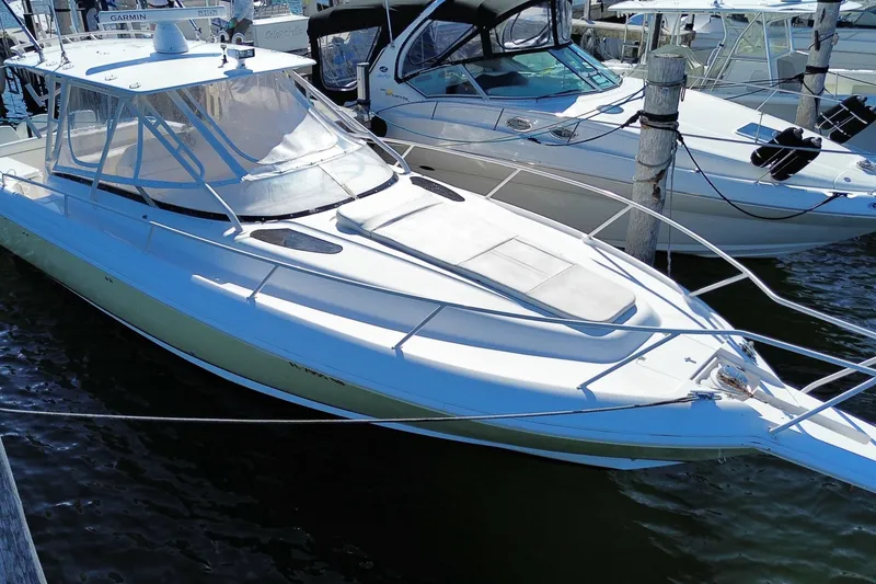 Slide: The Image of 2001 Intrepid 377 Walkaround boat docked at marina, featuring sleek design and spacious deck. - 10