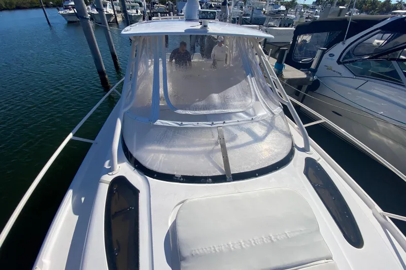 Slide: The Image of 2001 Intrepid 377 Walkaround boat docked at marina, featuring spacious deck and clear canopy. - 15