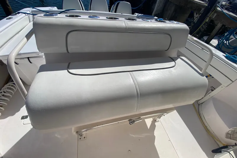 Slide: The Image of 2001 Intrepid 377 Walkaround boat seat with white upholstery and rod holders. - 24