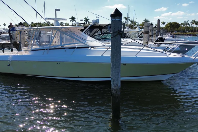 Slide: The Image of 2001 Intrepid 377 Walkaround boat docked in a marina under a clear blue sky. - 3