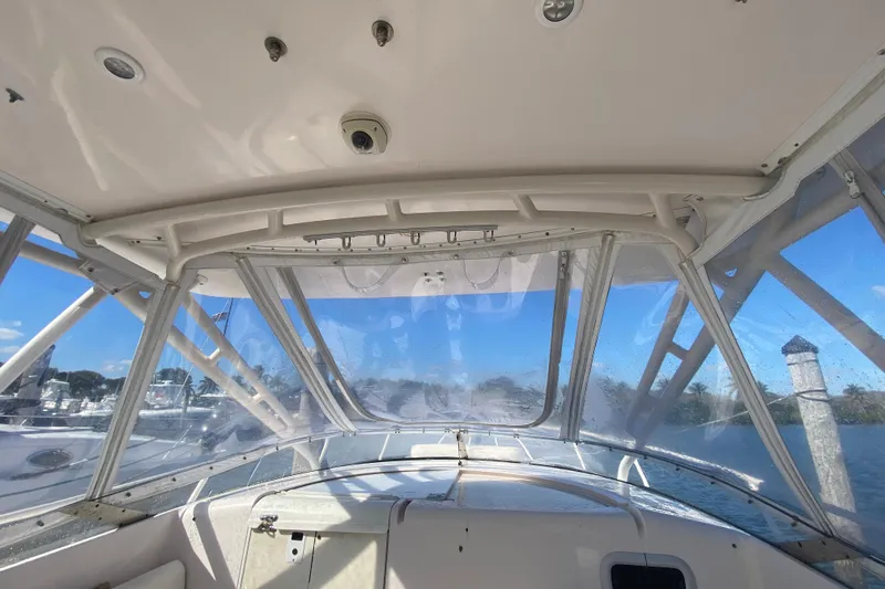 Slide: The Image of 2001 Intrepid 377 Walkaround boat interior with clear canopy and scenic water view. - 33