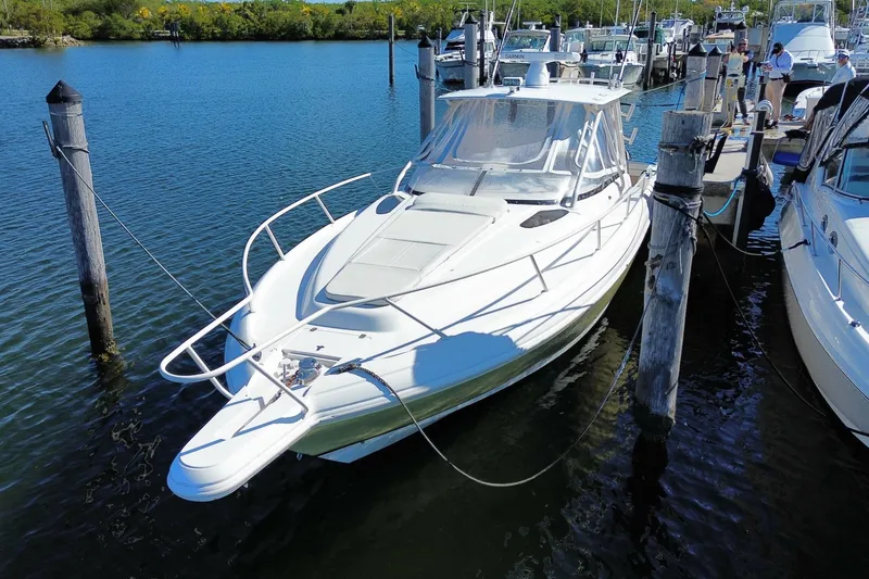Slide: The Image of 2001 Intrepid 377 Walkaround boat docked in a marina, surrounded by calm water. - 9