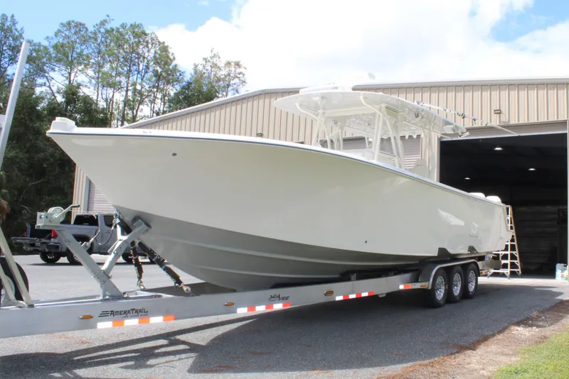 Slide: The Image of 2022 SeaVee 370Z boat on trailer outside a large garage. - 2