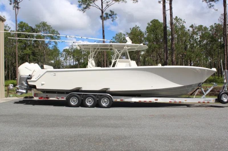 Slide: The Image of 2022 SeaVee 370Z boat on trailer, parked outdoors with trees in background. - 4