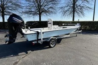 Slide: The Image of 2021 Skimmer Skiff Skimmer boat on trailer, parked outdoors with trees in background. - 3
