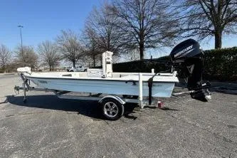 Slide: The Image of 2021 Skimmer Skiff boat on trailer, parked outdoors with trees in background. - 6