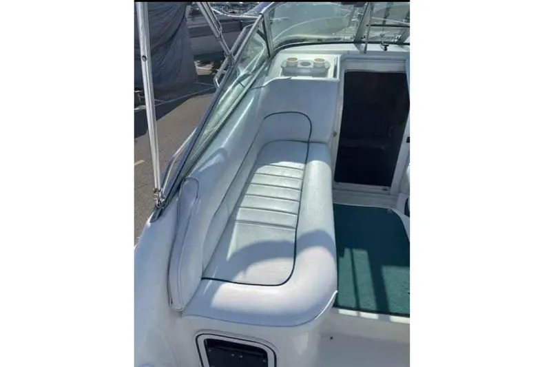 Slide: The Image of 1996 Sea Ray 270 Sundancer boat interior with cushioned seating and cup holders. - 5