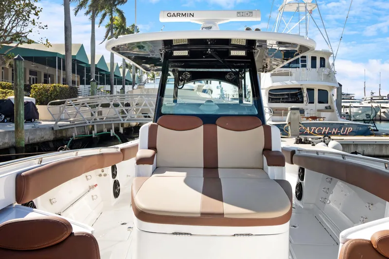 Slide: The Image of 2023 HCB Speciale boat interior with cushioned seating at a marina. - 12