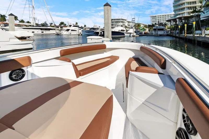 Slide: The Image of 2023 HCB Speciale boat interior with brown seating, docked in a marina. - 13