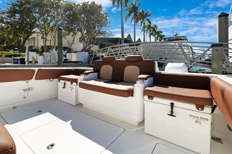 Slide: The Image of 2023 HCB Speciale boat interior with brown seating, docked at marina. - 16