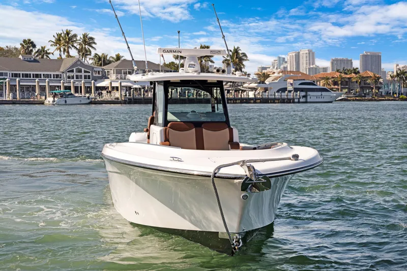 Slide: The Image of 2023 HCB Speciale boat cruising near a marina with city skyline backdrop. - 3