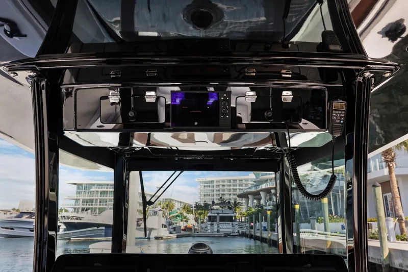 Slide: The Image of 2023 HCB Speciale boat dashboard with modern navigation equipment, docked at a marina. - 7