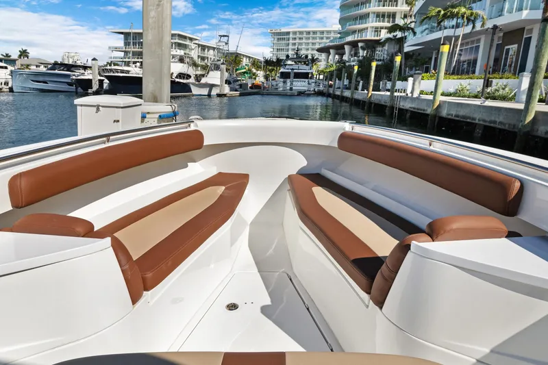 Slide: The Image of 2023 HCB Speciale boat interior with brown seating, docked in a marina. - 9