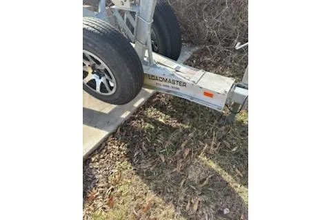 Slide: The Image of Trailer for 2016 Formula 310 Bowrider, Loadmaster brand, parked on grass. - 13
