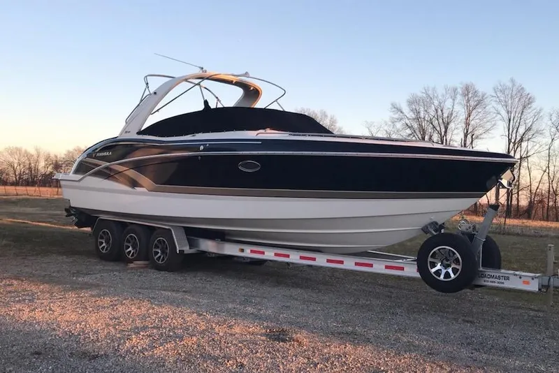 Slide: The Image of 2016 Formula 310 Bowrider boat on trailer, parked outdoors at sunset. - 2