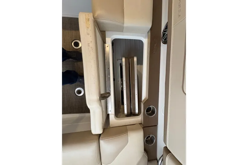 Slide: The Image of 2016 Formula 310 Bowrider interior storage compartment with beige seating and cup holders. - 39