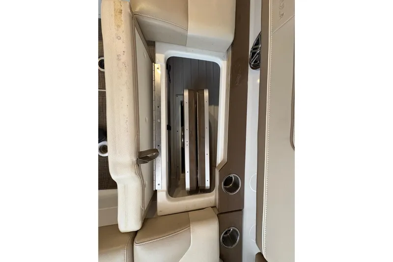 Slide: The Image of 2016 Formula 310 Bowrider interior storage compartment with beige seating and cup holders. - 40