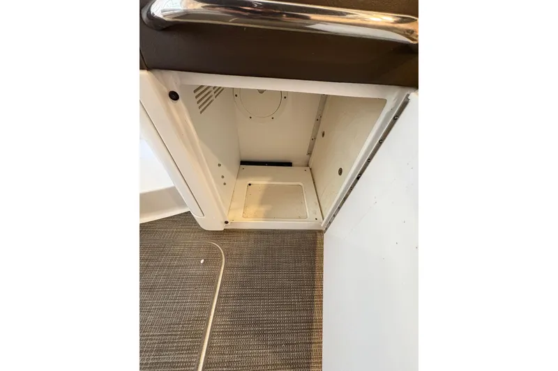 Slide: The Image of 2016 Formula 310 Bowrider storage compartment with carpeted flooring and metal handle. - 42