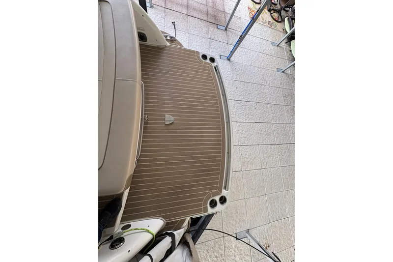 Slide: The Image of 2016 Formula 310 Bowrider boat deck with teak flooring, docked on tiled surface. - 46
