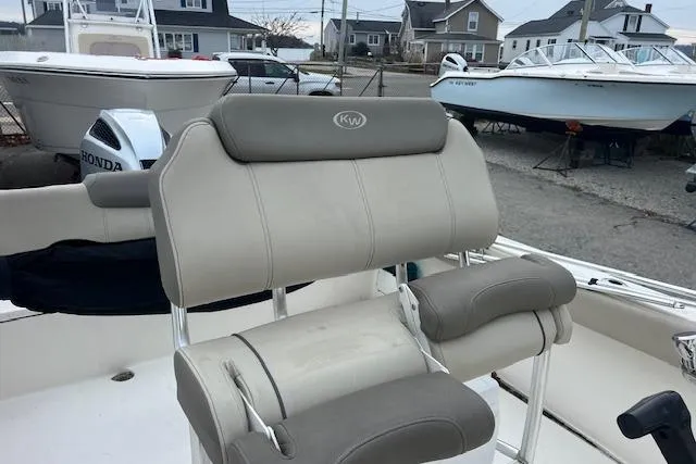 Slide: The Image of 2021 Key West 239 FS boat with cushioned seating, docked near other boats. - 7