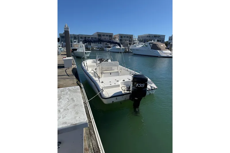 Slide: The Image of 2006 Boston Whaler 180 Dauntless boat docked in marina, clear blue water. - 3