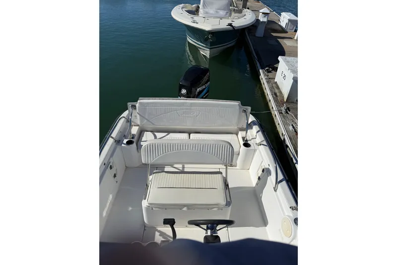 Slide: The Image of 2006 Boston Whaler 180 Dauntless boat interior with seating and steering wheel at dock. - 5