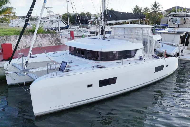 The Image of 2020 Lagoon 42 catamaran docked at marina, featuring sleek design and spacious deck. - 0