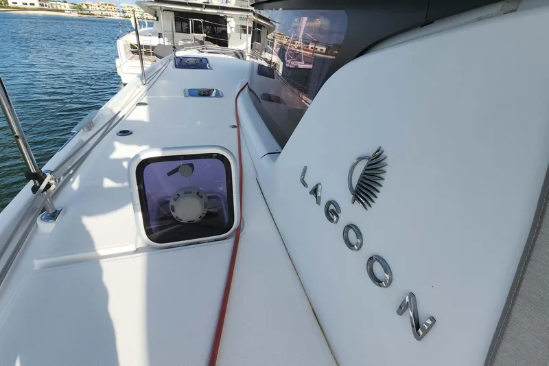 Slide: The Image of 2020 Lagoon 42 catamaran deck with logo, docked by the water. - 11