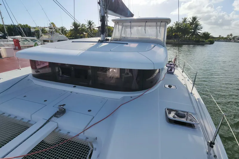 Slide: The Image of 2020 Lagoon 42 catamaran docked, featuring sleek design and spacious deck. - 12