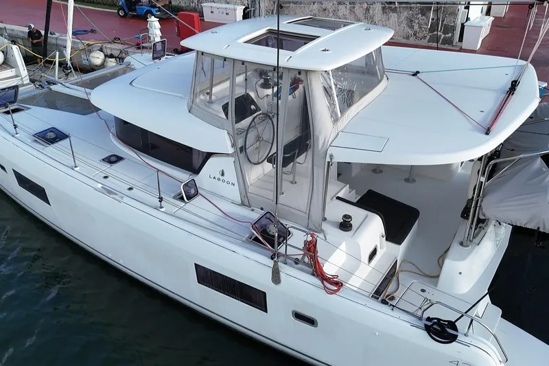 Slide: The Image of 2020 Lagoon 42 catamaran docked, featuring sleek design and spacious deck area. - 16