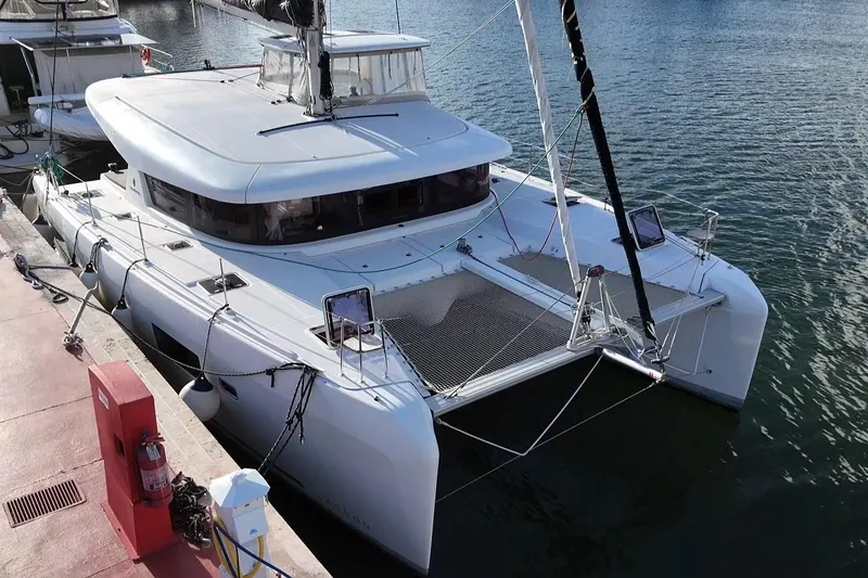 Slide: The Image of 2020 Lagoon 42 catamaran docked at marina, featuring sleek design and spacious deck. - 17