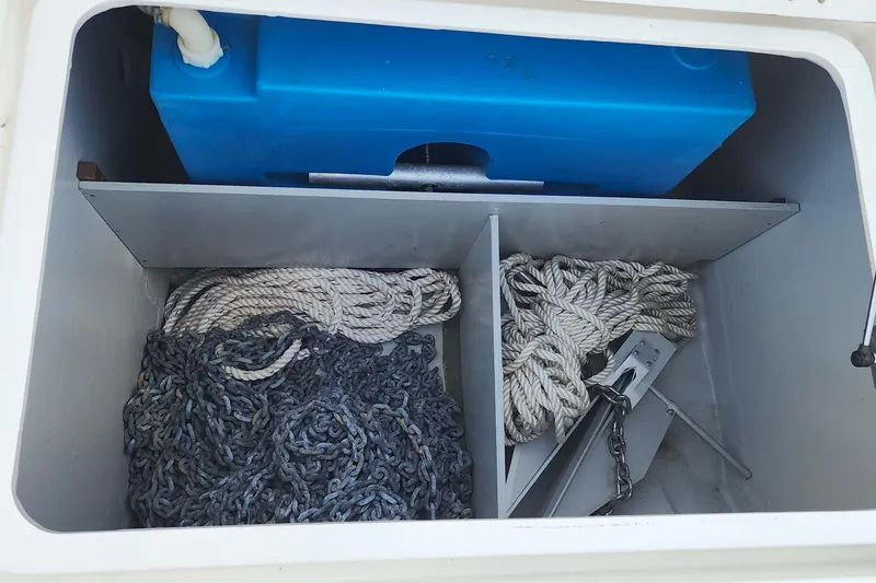 Slide: The Image of Storage compartment on a 2020 Lagoon 42 boat with ropes, chains, and a blue tank. - 23