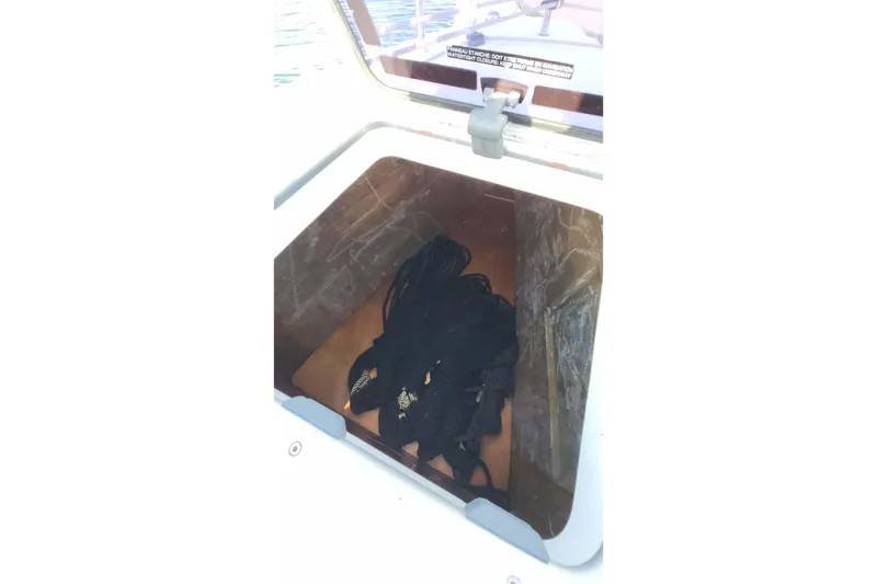 Slide: The Image of Storage compartment on a 2020 Lagoon 42 catamaran with coiled black ropes. - 26
