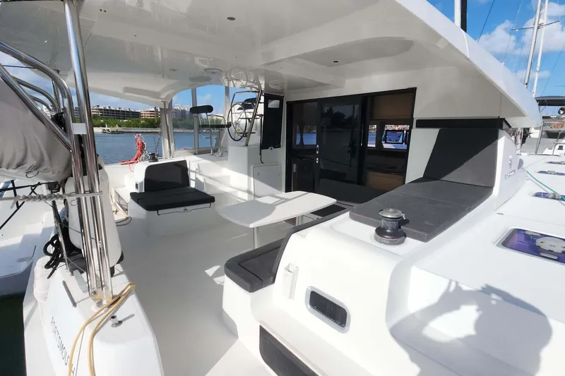 Slide: The Image of 2020 Lagoon 42 catamaran cockpit with seating, table, and marina view. - 3