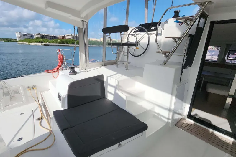 Slide: The Image of 2020 Lagoon 42 yacht cockpit with seating, steering wheel, and ocean view. - 4
