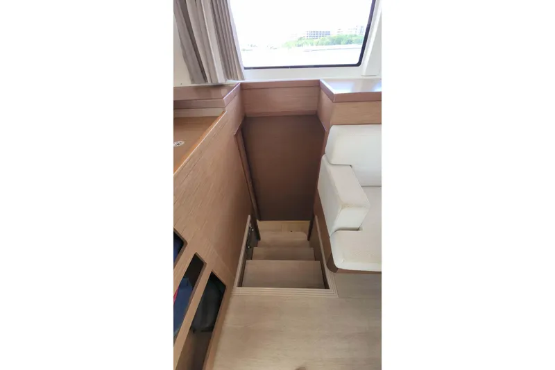 Slide: The Image of Interior stairs of 2020 Lagoon 42 catamaran with wooden finish and seating area. - 50