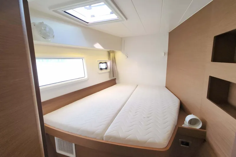 Slide: The Image of Interior cabin of 2020 Lagoon 42 catamaran with bed, window, and skylight. - 57