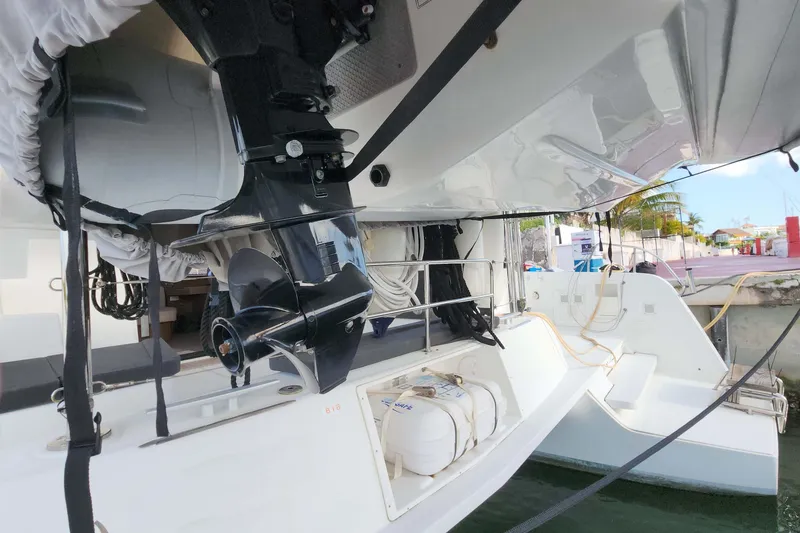 Slide: The Image of 2020 Lagoon 42 catamaran stern view with outboard motor and dockside setting. - 7
