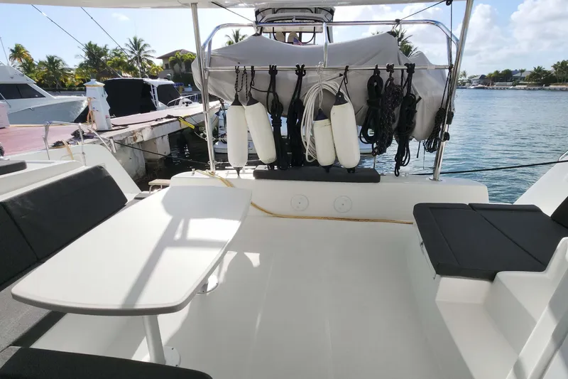 Slide: The Image of 2020 Lagoon 42 catamaran deck with seating, table, and ocean view. - 8