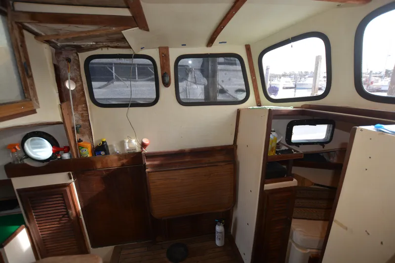 Slide: The Image of 1974 Fales Navigator boat interior with wooden cabinetry and windows. - 15