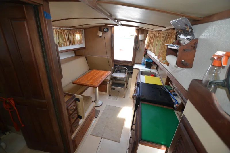 Slide: The Image of 1974 Fales Navigator boat interior with wooden furnishings and compact kitchen area. - 16