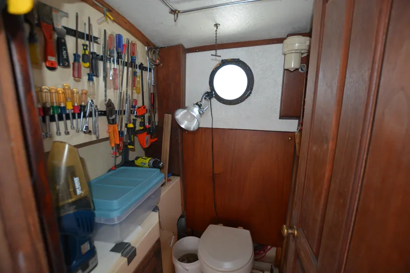 Slide: The Image of 1974 Fales Navigator boat interior with tools, porthole, and compact toilet area. - 17