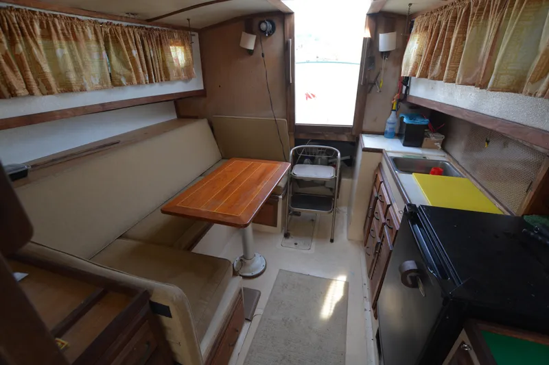 Slide: The Image of 1974 Fales Navigator boat interior with kitchenette, dining area, and vintage decor. - 19