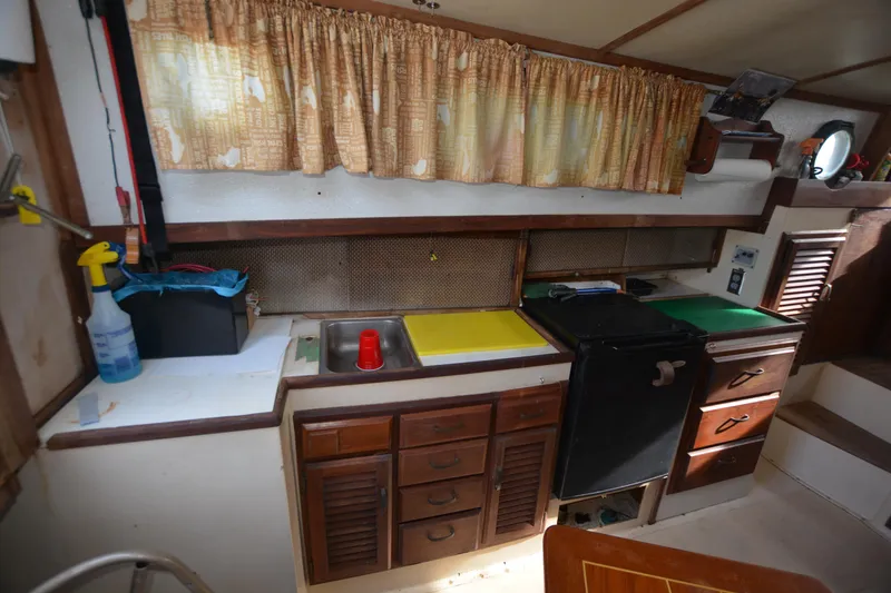 Slide: The Image of 1974 Fales Navigator boat kitchen with wooden cabinets, sink, and vintage decor. - 21