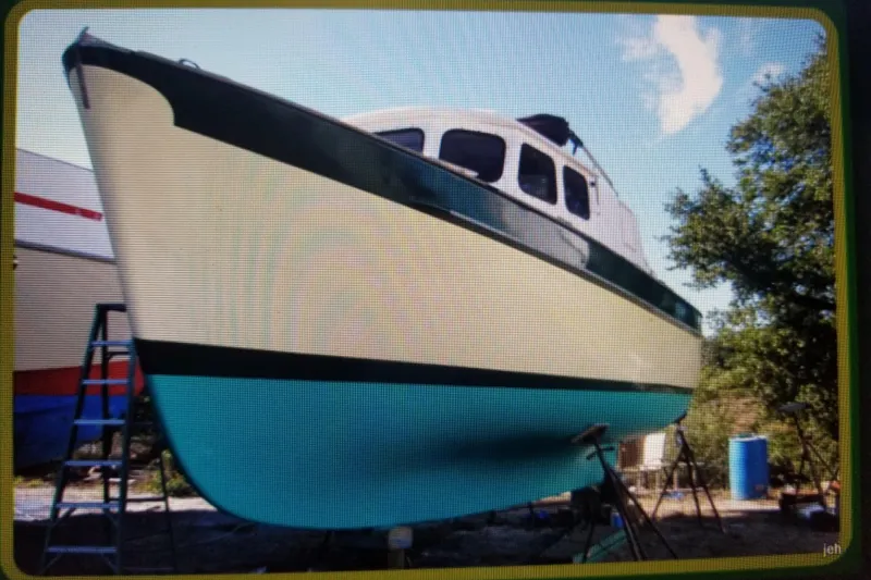Slide: The Image of 1974 Fales Navigator boat on dry dock, showcasing its hull and cabin design. - 4