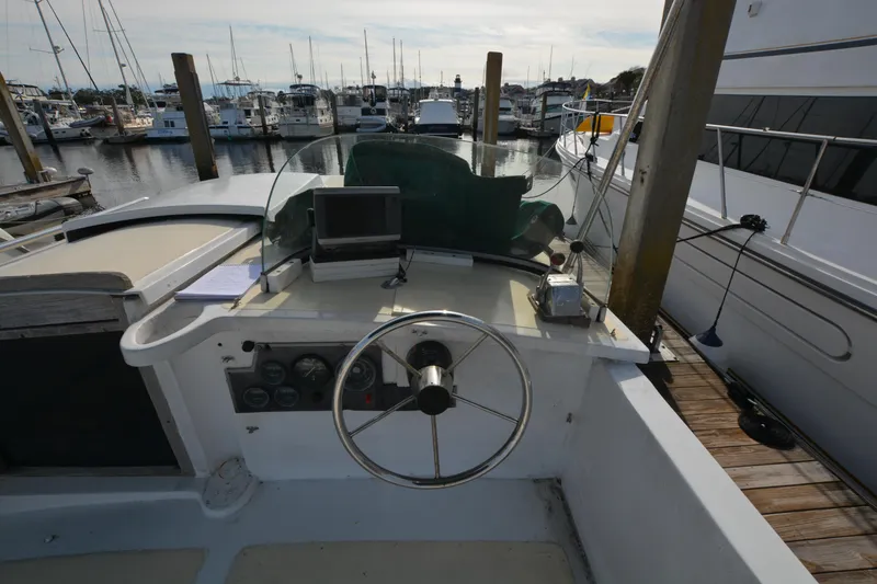 Slide: The Image of 1974 Fales Navigator boat helm with steering wheel and controls, docked at marina. - 6