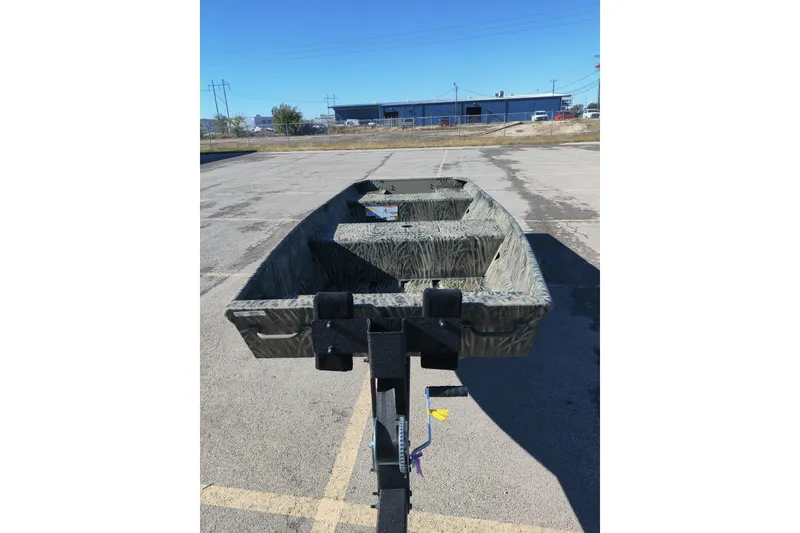 Slide: The Image of 2026 Tracker Grizzly 15 Jon boat on trailer in parking lot, clear sky background. - 3