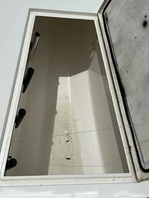 Slide: The Image of Open storage compartment on a 2000 Regulator 23' Center Console boat. - 15