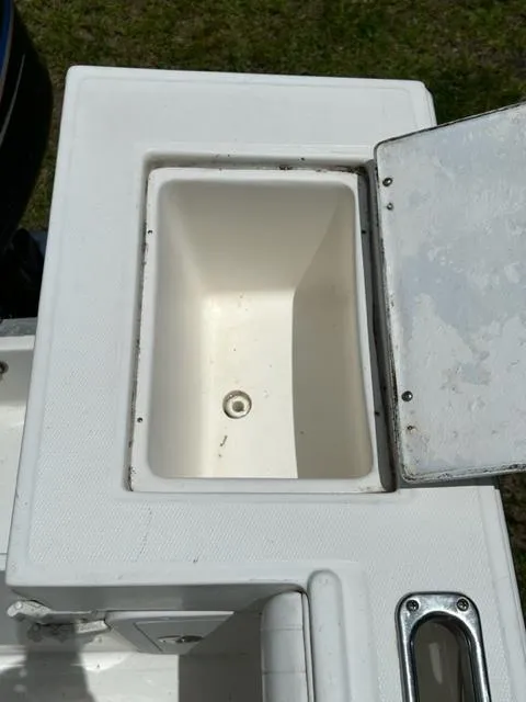 Slide: The Image of Regulator 23' Center Console 2000 boat storage compartment with open lid. - 20